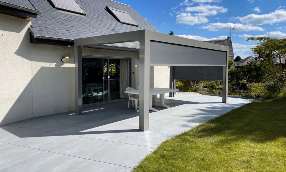 Terrasse extérieure moderne avec pergola bioclimatique aluminium gris anthracite à lames orientables, fixée en applique murale