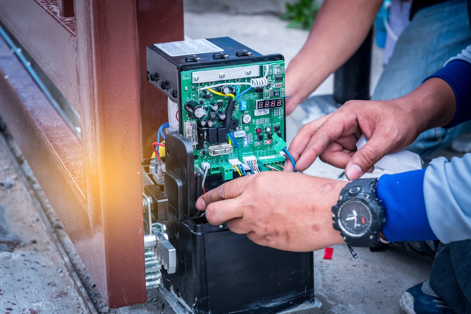 Un technicien monte et teste la porte automatique du moteur pour le système de sécurité domestique