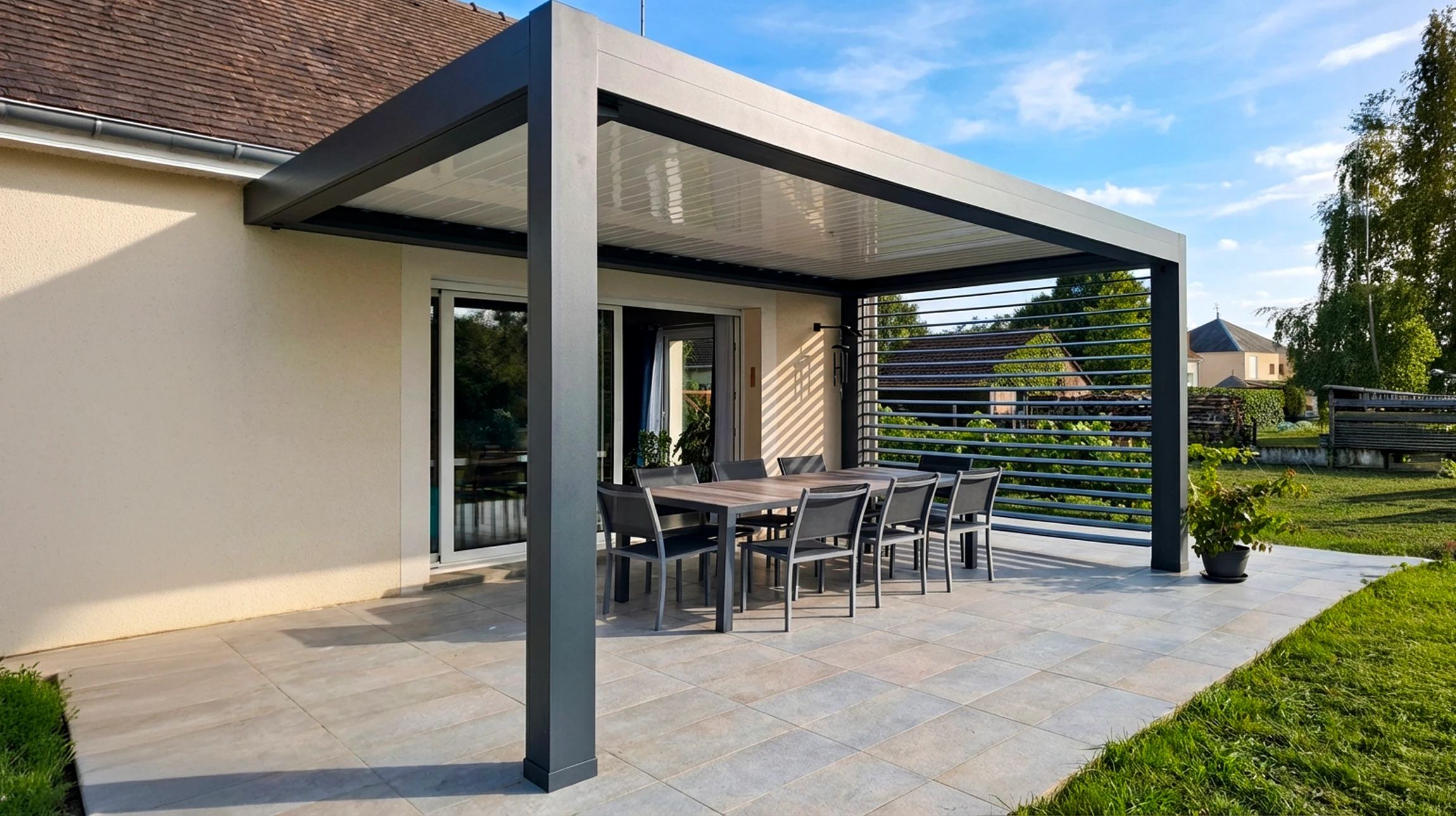 Terrasse extérieure moderne avec pergola bioclimatique à lames orientables en aluminium anthracite, adossée à une maison contemporaine
