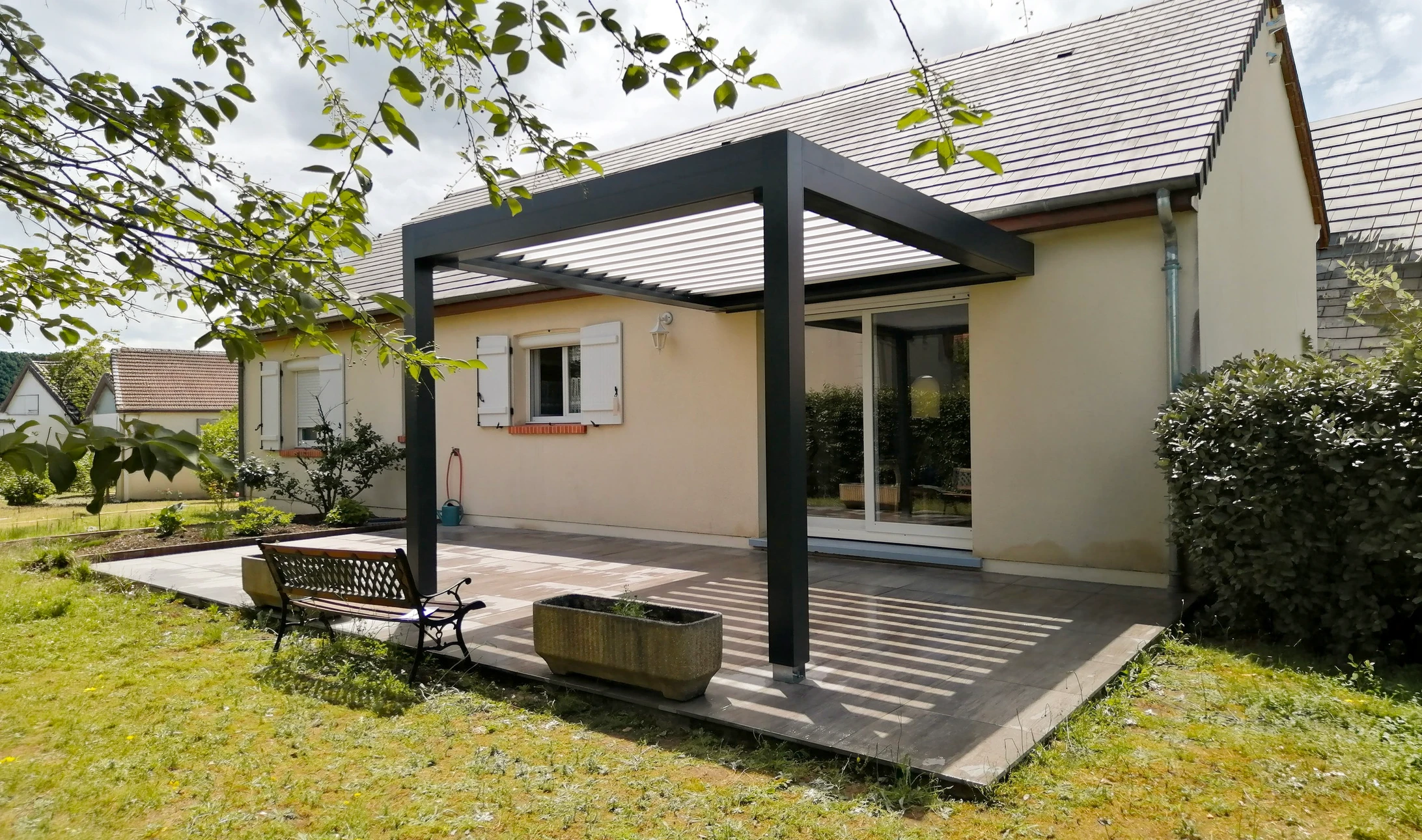 Deux ouvriers installent un volet roulant sur une baie vitrée extérieure d'une habitation