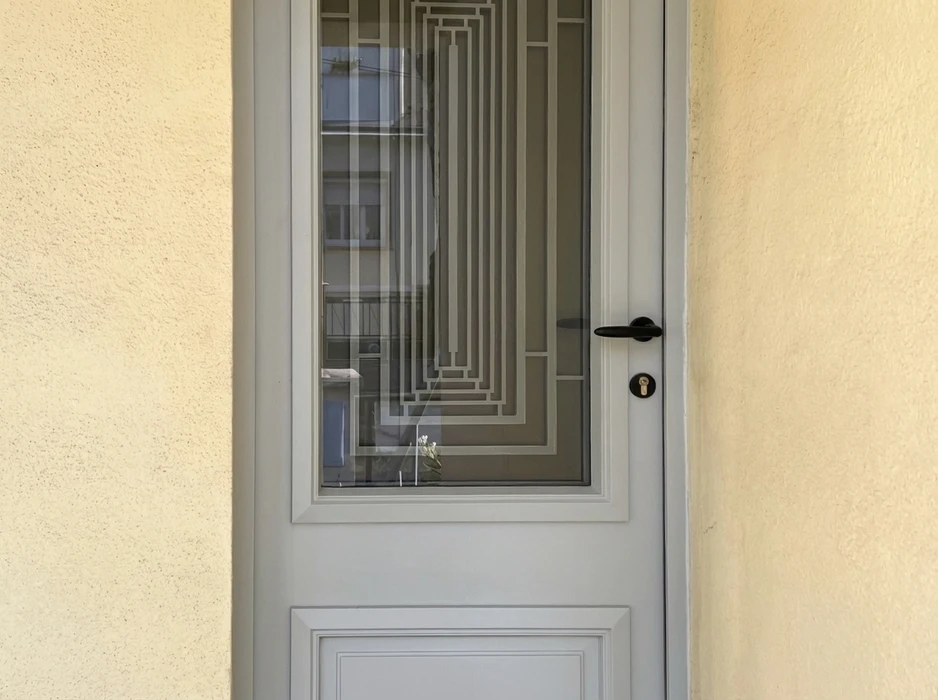 Façade extérieure d'une maison avec double porte-fenêtre à deux vantaux en PVC blanc