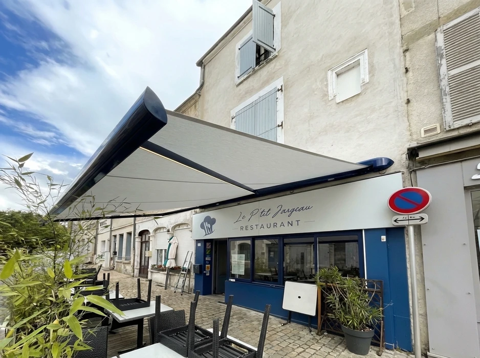 Terrasse extérieure moderne avec pergola bioclimatique à lames orientables en aluminium anthracite, fixée en appui mural