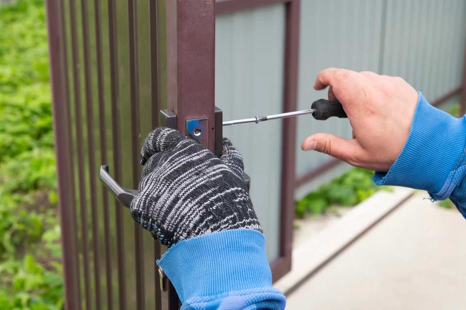 Un technicien monte et teste la porte automatique du moteur pour le système de sécurité domestique